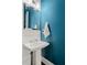 Powder room featuring a square mirror, classic pedestal sink and teal accent wall at 3024 Eamont Ter, Atlanta, GA 30328