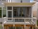 Close up of a screened in porch with a wooden deck, patio, and curtains for privacy at 3024 Eamont Ter, Atlanta, GA 30328