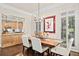 Dining room with white chairs, wood table, chandelier, modern art, and access to the kitchen and outdoor light at 3127 Lenox Ne Rd # 20, Atlanta, GA 30324