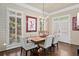 Bright dining room boasts natural light, white trim, modern art, chandelier, hardwood floors and white chairs at 3127 Lenox Ne Rd # 20, Atlanta, GA 30324