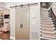 Hallway view featuring barn doors, staircase with carpeted steps and an iron railing at 3127 Lenox Ne Rd # 20, Atlanta, GA 30324
