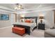 This main bedroom includes a tray ceiling, ceiling fan, upholstered bench and two bedside tables with lamps at 3127 Lenox Ne Rd # 20, Atlanta, GA 30324