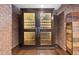 The custom wine cellar with glass doors displays bottles and provides temperature-controlled storage in a brick-walled setting at 3127 Lenox Ne Rd # 20, Atlanta, GA 30324