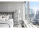 Bedroom showcasing a modern design with a cityscape view from floor-to-ceiling windows and a gray headboard at 3338 Peachtree Ne Rd # 3102, Atlanta, GA 30326