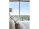 Bedroom featuring a plush bed with a gray headboard and soft, neutral bedding with views of the landscape at 3338 Peachtree Ne Rd # 3102, Atlanta, GA 30326