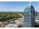Tall skyscraper with a unique top design, surrounded by lush green trees and a clear blue sky at 3338 Peachtree Ne Rd # 3102, Atlanta, GA 30326
