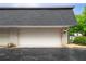 Attached two-car garage with a white door and brick facade, enhancing the home's curb appeal at 5105 Chemin De Vie, Atlanta, GA 30342