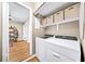 Convenient laundry area features a washer, dryer, storage shelves, and easy access to the home's interior at 5105 Chemin De Vie, Atlanta, GA 30342