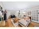 Spacious living room with hardwood floors, comfortable sectional sofa, and large windows at 5105 Chemin De Vie, Atlanta, GA 30342