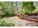 Lush backyard showcasing a stone patio, wooden deck, green lawn, and colorful plants and trees at 2469 Hunting Valley Dr, Decatur, GA 30033