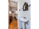 Charming bathroom featuring pedestal sink, vintage mirror and light fixtures, and a glimpse into the bedroom at 2469 Hunting Valley Dr, Decatur, GA 30033