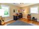Bedroom with hardwood floors, two windows, a desk, and a vintage-style area rug at 2469 Hunting Valley Dr, Decatur, GA 30033