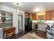 Kitchen features wooden cabinets, black appliances, and view to entry hall and additional dining space at 2469 Hunting Valley Dr, Decatur, GA 30033