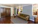 Living room with wood floors, gray brick, closet, olive sofa, and open view to kitchen at 2469 Hunting Valley Dr, Decatur, GA 30033