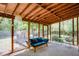 Relaxing screened porch with wood beams, hanging lights, seating, and views of the lush backyard at 2469 Hunting Valley Dr, Decatur, GA 30033