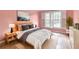 Bedroom with pink walls, a bed, two windows, and neutral-colored accents at 2636 Harvest Se Dr, Conyers, GA 30013