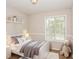 Staged bedroom with shelf decor, bed, teddy bear, and plenty of natural light from window at 3790 Willow Ridge Rd, Douglasville, GA 30135
