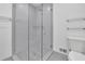 Glass shower with gray tile and patterned floor accompanied by toilet with white ceramic at 4973 Gunners Ne Pass, Roswell, GA 30075