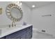 Stylish bathroom with a white countertop, navy blue vanity, and decorative mirror at 4973 Gunners Ne Pass, Roswell, GA 30075