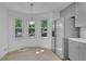 Bright kitchen featuring gray cabinetry, stainless steel fridge, and a breakfast nook area with three windows at 4973 Gunners Ne Pass, Roswell, GA 30075