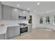 Modern kitchen featuring stainless steel appliances, gray cabinetry, white countertops, and natural light at 4973 Gunners Ne Pass, Roswell, GA 30075