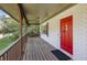 A covered porch with a red front door and a wooden railing at 4973 Gunners Ne Pass, Roswell, GA 30075
