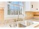 Close-up of kitchen sink area with granite countertops, new faucet, and lots of natural light at 5465 N Fork Sw Dr, Lilburn, GA 30047