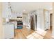 Well-lit kitchen with wood flooring, white cabinets and stainless steel appliances at 5465 N Fork Sw Dr, Lilburn, GA 30047