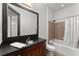 Bathroom featuring dark wood cabinets, sink, shower, and white bathtub at 747 Ralph Mcgill Ne Blvd # 223, Atlanta, GA 30312