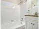 Bathroom with white tile surround, tub, and vanity with granite countertop at 1667 Hollyhock Ter, Decatur, GA 30032