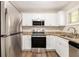 Bright kitchen featuring stainless steel appliances, granite countertops, and white cabinets at 1667 Hollyhock Ter, Decatur, GA 30032