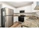 Modern kitchen featuring stainless steel appliances, granite countertops, and white cabinets, offering both style and functionality at 1667 Hollyhock Ter, Decatur, GA 30032