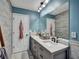 Stylish bathroom with a double vanity, decorative mirror, and wood-look wall tiles at 59 Sentry Rdg, Dallas, GA 30157