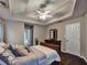 Main bedroom showcases a tray ceiling with fan, dark wood floors, and access to the main bathroom at 59 Sentry Rdg, Dallas, GA 30157