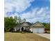 Charming, light yellow single-story home with well-maintained lawn and shrubbery plus an attached two-car garage at 59 Sentry Rdg, Dallas, GA 30157