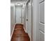 Hallway with hardwood floors, white trim, and doors leading to various rooms, lit by a ceiling light at 59 Sentry Rdg, Dallas, GA 30157