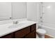 Clean bathroom with dark wood vanity and shower-tub combo with white tiling at 7431 St David St, Fairburn, GA 30213