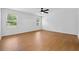 Large bedroom with wood-look flooring, two windows, ceiling fan and white walls at 7431 St David St, Fairburn, GA 30213