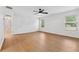 Bedroom with wood-look flooring, white walls, ceiling fan and two windows at 7431 St David St, Fairburn, GA 30213