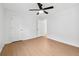 Bedroom with hardwood floors, white walls, ceiling fan, and ample closet space at 7431 St David St, Fairburn, GA 30213