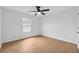 Minimalist bedroom featuring hardwood floors, ceiling fan, and bright window at 7431 St David St, Fairburn, GA 30213