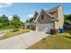 View of the side of the house and driveway with a two-car garage on a sunny day at 7431 St David St, Fairburn, GA 30213