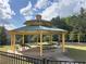 A covered picnic area with multiple picnic tables and mature trees in the background at 7431 St David St, Fairburn, GA 30213