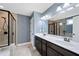 Bathroom featuring double vanity, large mirror, shower with glass door, and neutral walls at 924 Woodbury Rd, Canton, GA 30114