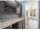 Butler's pantry with granite counters, dark wood cabinets and glass doors, and view to dining room at 924 Woodbury Rd, Canton, GA 30114