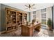 Comfortable home office with custom built-in shelves, a large desk, and natural light from the windows at 924 Woodbury Rd, Canton, GA 30114