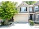 Charming townhome featuring an attached garage, neutral colors, and a beautiful landscaped yard with flowering plants at 1058 Mays Sw Hl, Atlanta, GA 30336