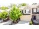 Charming townhome with an attached garage, neutral colors, and a well-maintained landscaped yard with flowering plants at 1058 Mays Sw Hl, Atlanta, GA 30336