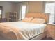 Comfortable primary bedroom with tufted headboard, soft lighting, and two large windows at 1058 Mays Sw Hl, Atlanta, GA 30336