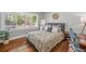 Bright bedroom features wood floors, neutral walls, a large window, and a comfortable queen-sized bed with stylish linens at 1089 Greenleaf Se Rd, Atlanta, GA 30316